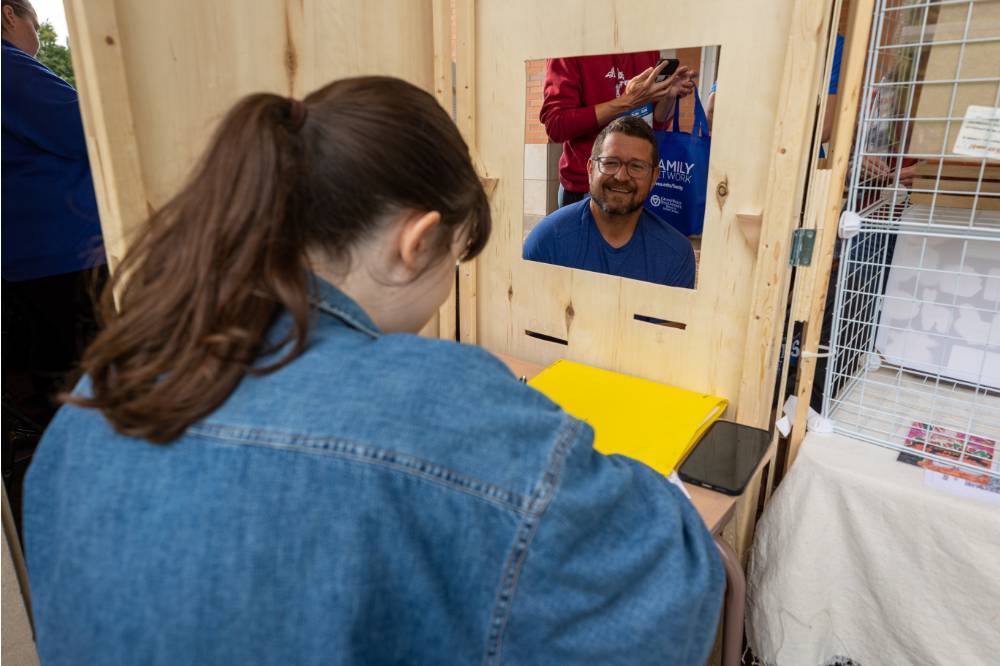 Student draws portrait of another attendee during Student Small Business Market.